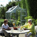 Two ladies enjoying a drink in front of their rhino greenhouse